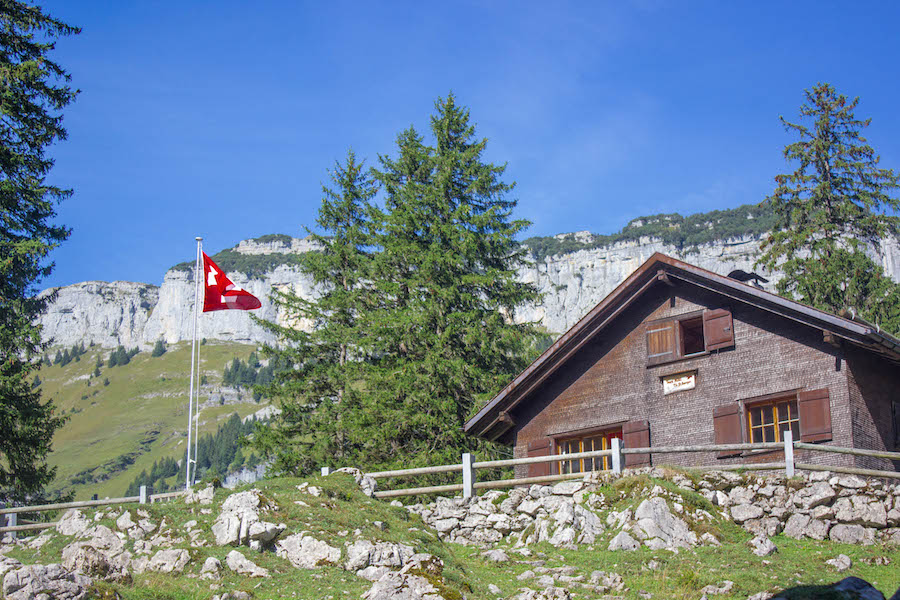 Wandern in den Schweizer Alpen - Berghütte mit schweizer Flagge